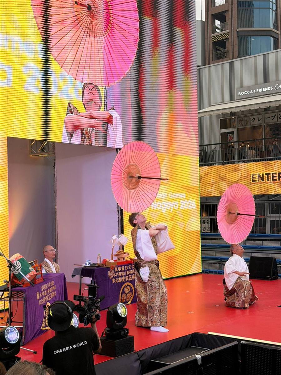 ステージで太神楽の傘の曲芸を披露する様子