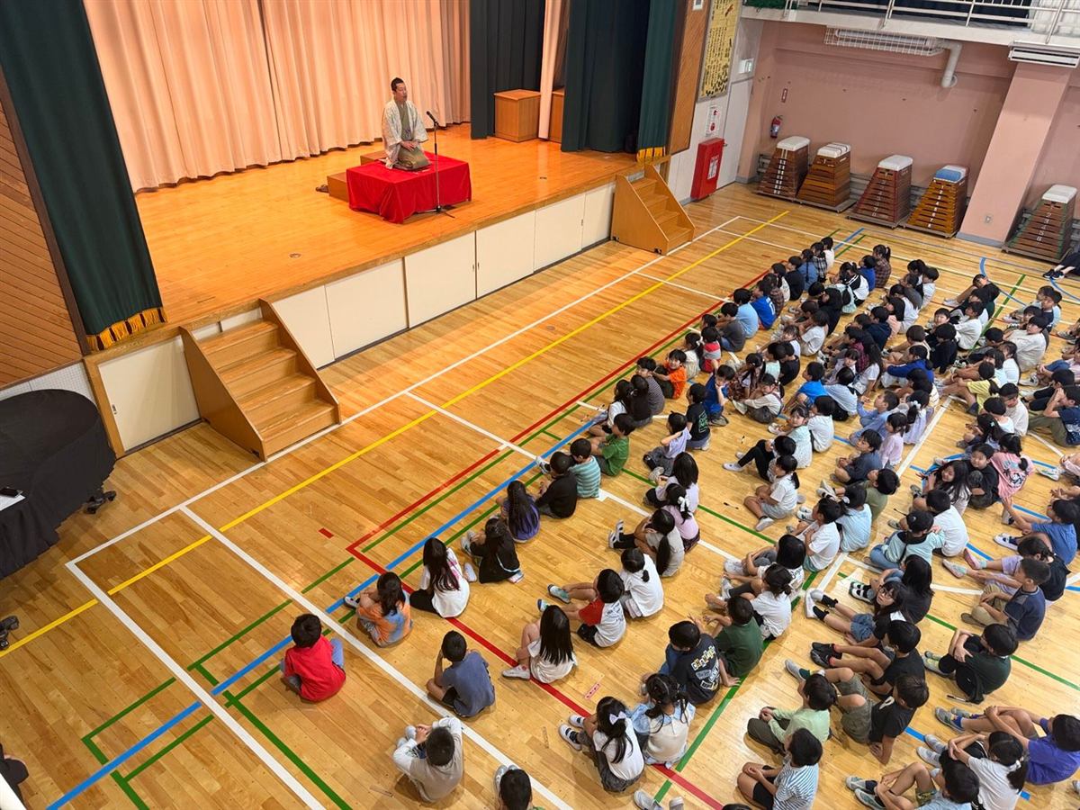 小学校の体育館で落語を鑑賞する子どもたち